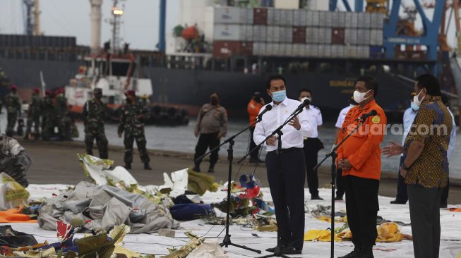 Wakil Ketua DPR Azis Syamsuddin (kiri) memberikan keterangan kepada awak media saat meninjau penanganan evakuasi pesawat Sriwijaya Air SJ 182 di Dermaga JICT, Tanjung Priok, Jakarta, Senin (11/1/2021). [Suara.com/Angga Budhiyanto]