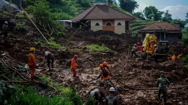 Anggota Basarnas, TNI, Polri dan relawan melakukan pencarian korban bencana tanah longsor di Cimanggung, Kabupaten Sumedang, Jawa Barat, Selasa (12/1/2021).   [ANTARA FOTO/Raisan Al Farisi]
