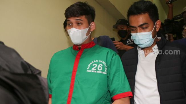 Suami dari Penyanyi Nindy Ayunda, Askara Parasady Harsono dibawa keluar dari ruang tahanan sebagai tersangka kasus penyalahgunaan narkoba di Polres Metro Jakarta Barat, Selasa (12/1/2021). [Suara.com/Alfian Winanto]