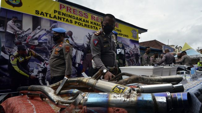 Polisi menunjukkan sejumlah knapot tak standar (knalpot racing) hasil razia di Poresta Bandar Lampung, Lampung, Selasa (12/1/2021). [ANTARA FOTO/Ardiansyah]