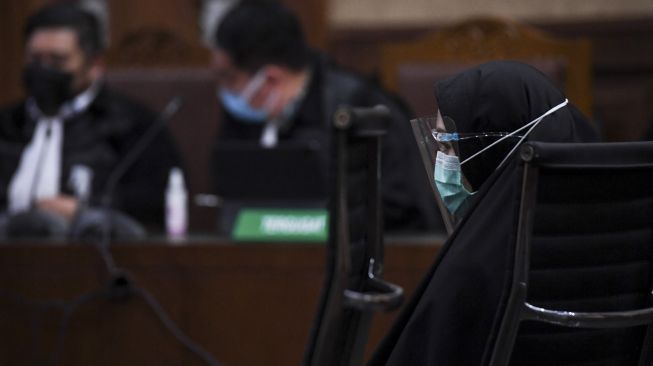 Terdakwa kasus penerimaan suap dari Djoko Tjandra terkait pengurusan fatwa Mahkamah Agung (MA), Pinangki Sirna Malasari mendengarkan tuntutan jaksa saat menjalani sidang lanjutan di Pengadilan Tipikor, Jakarta, Senin (11/1/2021). [ANTARA FOTO/Hafidz Mubarak]