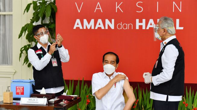 Presiden Joko Widodo (tengah) bersiap disuntik dosis pertama vaksin COVID-19 produksi Sinovac oleh vaksinator Wakil Ketua Dokter Kepresidenan Prof Abdul Mutalib (kanan) di beranda Istana Merdeka, Jakarta, Rabu (13/1/2021). [ANTARA FOTO/HO/Setpres-Agus Suparto]