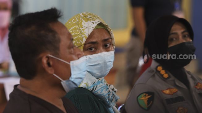 Ekspresi keluarga dari Okky Bisma yang merupakan korban kecelakaan pesawat Sriwijaya Air nomor penerbangan SJ 182 saat menjawab pertanyaan wartawan usai mengurus pengambilan jenazah anaknya di Posko Ante Mortem, RS Polri Kramatjati, Jakarta, Rabu (13/1/2021). [Suara.com/Angga Budhiyanto]