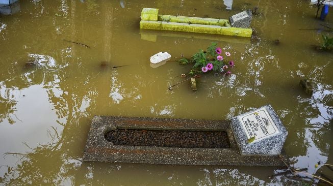 Sebuah makam yang terendam banjir akibat luapan Sungai Citanduy di Tempat Pemakaman Umum (TPU) Desa Kertaraharja, Kecamatan Panumbangan, Kabupaten Ciamis, Jawa Barat, Kamis (14/1/2021). [ANTARA FOTO/Adeng Bustomi]