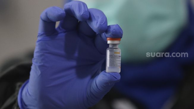 Petugas medis menunjukkan vaksin COVID-19 Sinovac yang akan disuntikan kepada tenaga kesehatan di Puskesmas Duren Sawit, Jakarta, (14/1/2021). [Suara.com/Angga Budhiyanto]