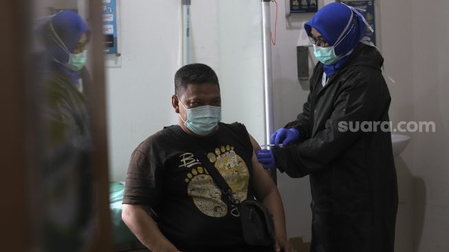 Petugas medis menyuntikan vaksin COVID-19 Sinovac kepada seorang tenaga kesehatan di Puskesmas Duren Sawit, Jakarta, (14/1/2021). [Suara.com/Angga Budhiyanto]