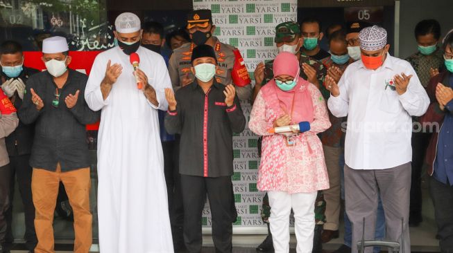 Ustaz Yusuf Mansur (tengah) bersama dengan keluarga berdoa untuk jenazah Syekh Ali Jaber di Rumah Sakit Yarsi, Cempaka Putih, Jakarta Timur, Kamis (14/1/2021). [Suara.com/Alfian Winanto]