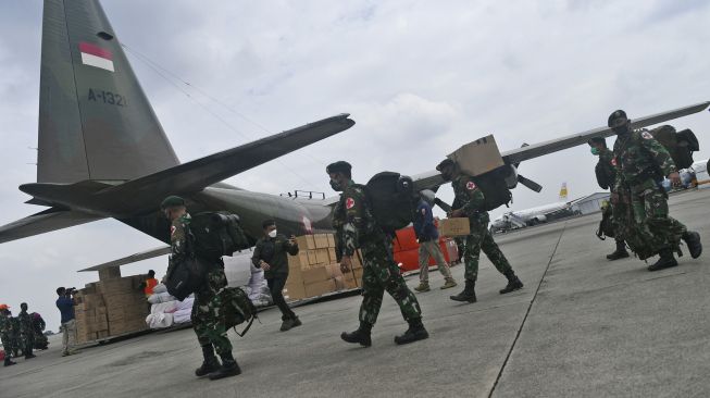 Prajurit TNI bersiap memasuki Pesawat Hercules A 1321 TNI AU yang membawa bantuan logistik untuk korban gempa bumi Majene di Lanud Halim Perdanakusuma, Jakarta, Jumat (15/1/2021). [ANTARA FOTO/Sigid Kurniawan]