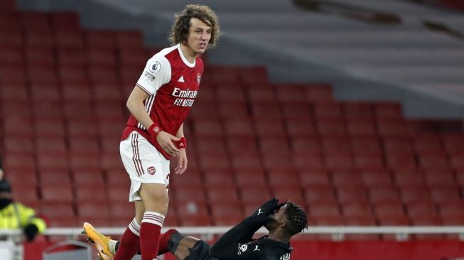 Bek Arsenal David Luiz usai menjatuhkan penyerang Crystal Palace Wilfried Zaha dalam laga lanjutan Liga Inggris di Emirates Stadium, London, Jumat (15/1/2021) dini hari WIB. [Alastair Grant / POOL / AFP].