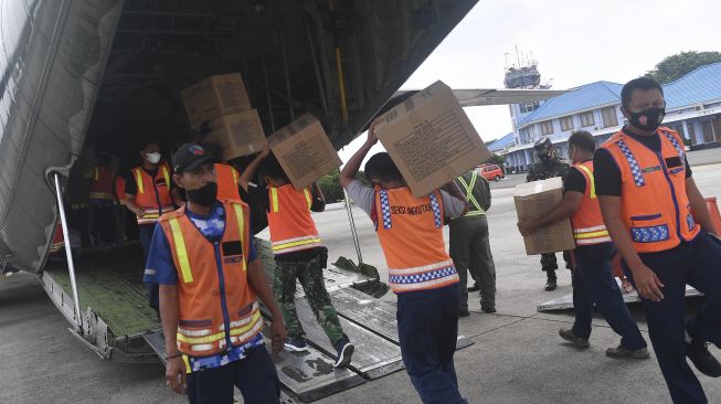 Petugas memasukkan logistik bantuan untuk korban gempa bumi Majene kedalam Pesawat Hercules A 1321 TNI AU, di Lanud Halim Perdanakusuma, Jakarta, Jumat (15/1/2021).  [ANTARA FOTO/Sigid Kurniawan]