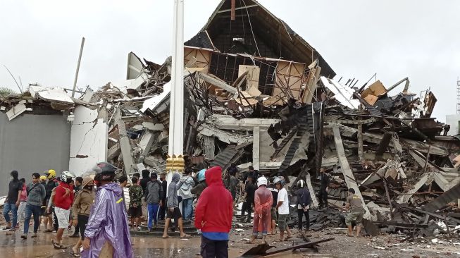 Warga mengamati Gedung Kantor Gubernur Sulawesi Barat yang rusak akibat gempa bumi, di Mamuju, Sulawesi Barat, Jumat (15/1/2021). [ANTARA FOTO/Akbar Tado]