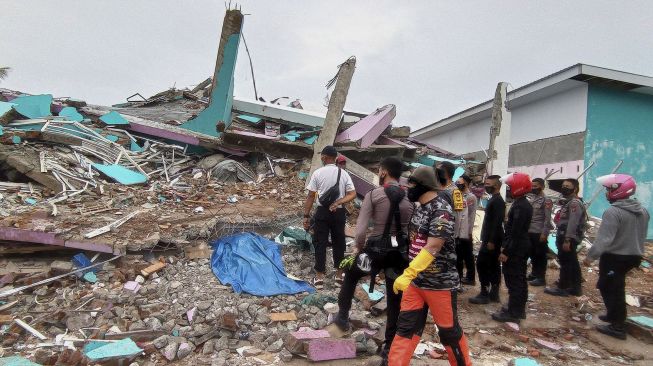 Petugas mengamati bangunan RS Mitra Manakarra yang roboh pascagempa bumi, di Mamuju, Sulawesi Barat, Jumat (15/1/2021). [ANTARA FOTO/Akbar Tado]