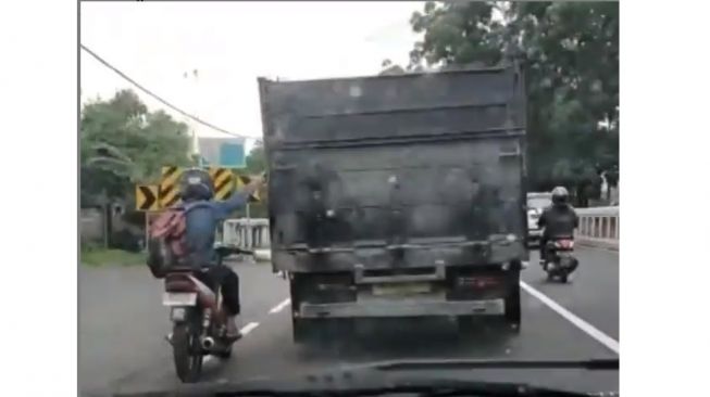 Aksi pemotor berbahaya ketika kehabisan bensin di jalan, ikutan truk yang melintas (Instagram)