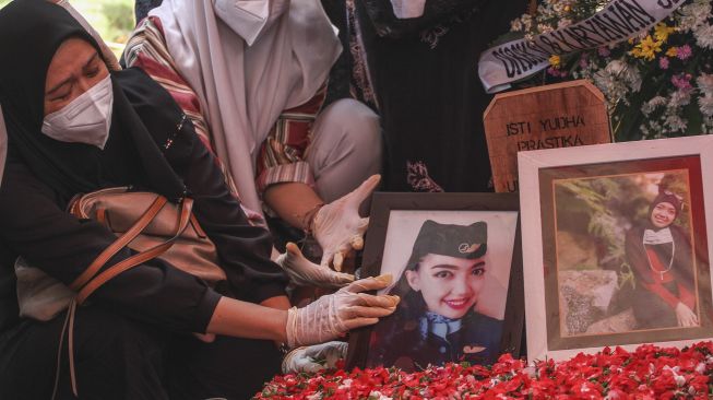 Keluarga dan kerabat menabur bunga di pusara pramugari Isti Yudha Prastika korban kecelakaan Sriwijaya Air SJ 182 di TPU Pondok Petir, Depok, Jawa Barat, Sabtu (16/1/2021). [ANTARA FOTO/Asprilla Dwi Adha]