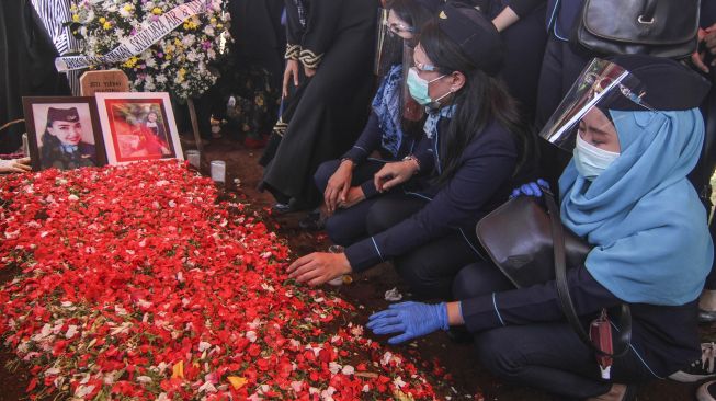 Keluarga dan kerabat menabur bunga di pusara pramugari Isti Yudha Prastika korban kecelakaan Sriwijaya Air SJ 182 di TPU Pondok Petir, Depok, Jawa Barat, Sabtu (16/1/2021). [ANTARA FOTO/Asprilla Dwi Adha]