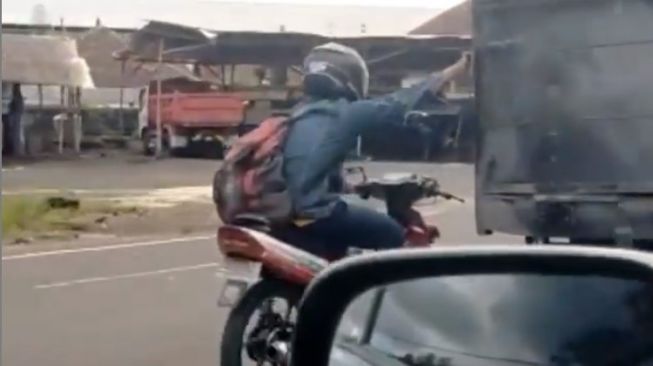 Unik Tapi Berbahaya, Pemotor Pegangan Truk di Jalan saat Kehabisan Bensin