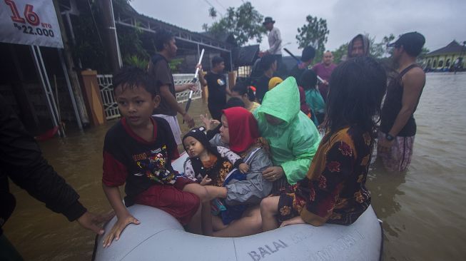 Sejumlah relawan menggunakan perahu karet membantu evakuasi warga yang terdampak banjir di Desa Kampung Melayu, Kabupaten Banjar, Kalimantan Selatan, Jumat (15/1/2021). [ANTARA FOTO/Bayu Pratama S]