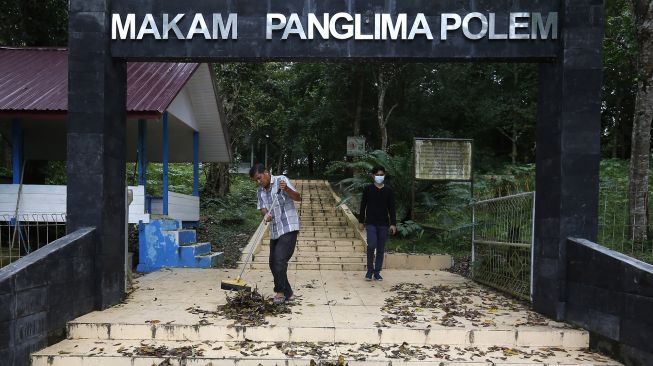 Pekerja membersihkan komplek makam pahlawan nasional Panglima Polem di Desa Lamsie, Aceh Besar, Aceh, Minggu (17/1/2021). [ANTARA FOTO/Irwansyah Putra]
