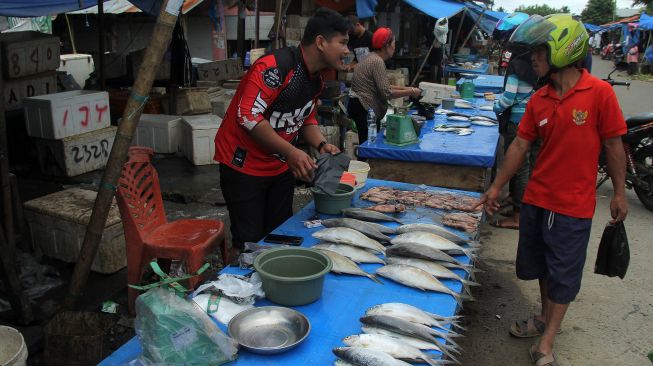 Penjual menawarkan barang dagangannya di pasar baru Mamuju, Sulawesi Barat, Minggu (17/1/2021).  ANTARA FOTO/ Akbar Tado
