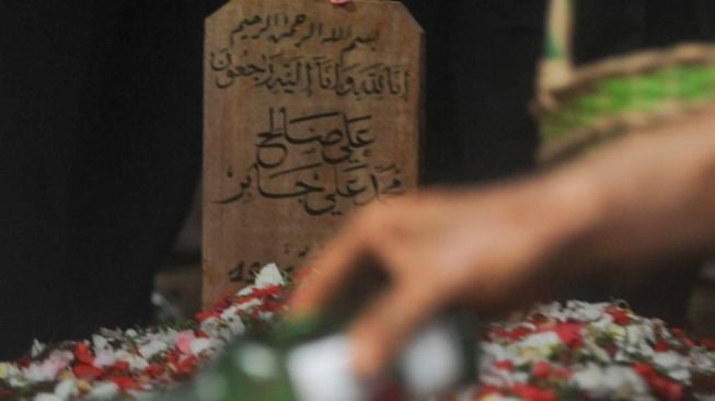 Makam Syekh Ali Jaber dengan batu nisan bertuliskan arab usai dimakamkan di Pesantren Daarul Quran, Tangerang, Banten, Kamis (14/1/2021). [Suara.com/Alfian Winanto]