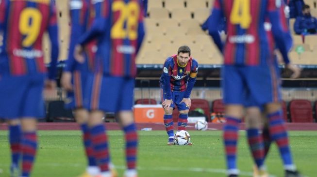 Penyerang Barcelona, Lionel Messi jelang mengambil tendangan bebas saat menghadapi Athletic Bilbao dalam laga final Piala Super Spanyol, Senin (18/1/2021) dini hari WIB. [CRISTINA QUICLER / AFP].
