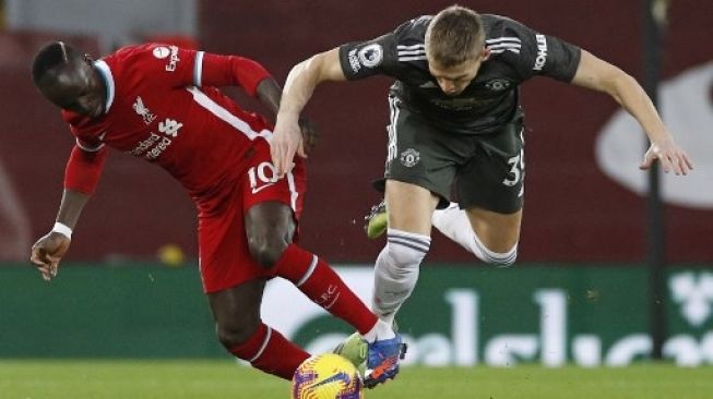 Pemain Liverpool Sadio Mane (kiri) dan gelandang Manchester United Scott McTominay berebut bola dalam laga lanjutan Liga Inggris di Anfield (17/1/2021). PHIL NOBLE / POOL / AFP