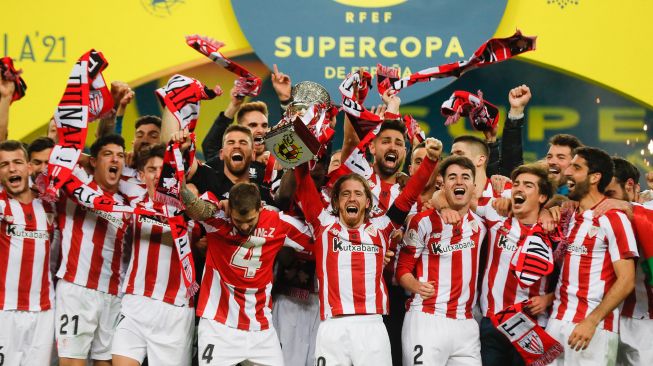 Para pemain Athletic Bilbao merayakan kemenangan setelah memenangkan pertandingan final Piala Super Spanyol antara FC Barcelona di Stadion La Cartuja, Senin (18/1/2021) dini hari WIB. [Pablo GARCIA / RFEF / AFP