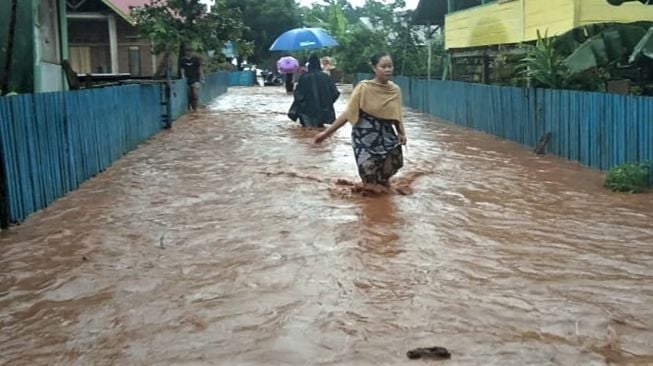 Warga menerobos banjir di Kecamatan Kabaena Selatan, Kabupaten Bombana, Sulawesi Tenggara, Senin [ANTARA FOTO]