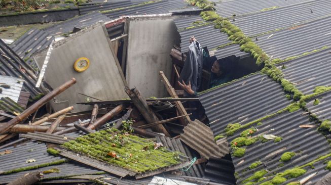 Warga menyelamatkan barang pasca banjir bandang di Kampung Gunung Mas, Tugu Selatan, Cisarua, Kabupaten Bogor, Jawa Barat, Selasa (19/1/2021).  [ANTARA FOTO/Yulius Satria Wijaya]