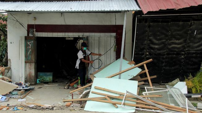 Warga mencari harta benda yang masih bisa diselamatkan dari rumahnya pascagempa bumi di Mamuju, Sulawesi Barat, Selasa (19/1/2021).  [ANTARA FOTO/Akbar Tado]