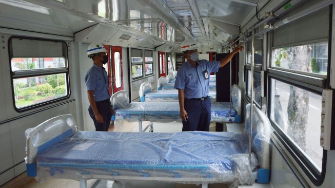 Petugas memeriksa bagian dalam Kereta Rel Listrik (KRL) yang dimodifikasi menjadi Kereta Medik Darurat, di PT INKA (Persero) Madiun, Jawa Timur, Kamis (21/1/2021). . [ANTARA FOTO/Siswowidodo]
