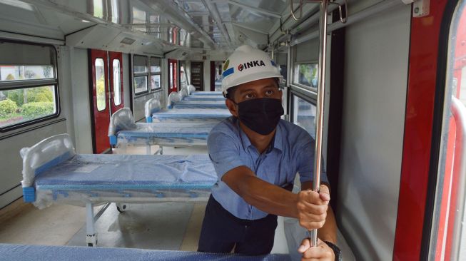 Petugas melihat Kereta Rel Listrik (KRL) yang dimodifikasi menjadi Kereta Medik Darurat di PT INKA (Persero) Madiun, Jawa Timur, Kamis (21/1/2021).  [ANTARA FOTO/Siswowidodo]
