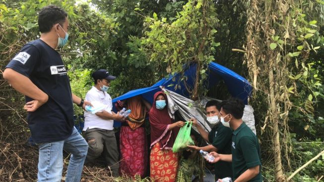 Relawan PLN membagikan makanan kepada korban gempa Majene dan Mamuju, Sulawesi Barat, di lokasi pengungsian / [Foto PLN]