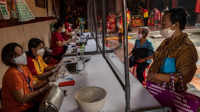 Warga lanjut usia (lansia) antre pembagian angpau dari Yayasan Kelenteng Tay Kak Sie di Semarang, Jawa Tengah, Jumat (22/1/2021).  [ANTARA FOTO/Aji Styawan]
