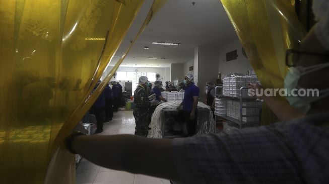 Sejumlah tenaga non medis menyiapkan makanan untuk tenaga kesehatan dan pasien COVID-19 di Rumah Sakit Darurat Penanganan COVID-19 Wisma Atlet Kemayoran, Jakarta, Jumat (22/1/2021). [Suara.com/Angga Budhiyanto]