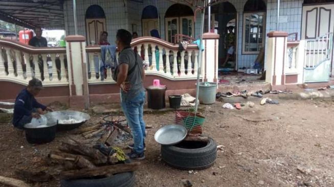 Warga di dapur umum posko banjir di Kabupaten Banjar, Kalimantan Selatan, terpaksa beralih ke kayu bakar untuk memenuhi kebutuhan memasak lantaran mahal dan langkanya gas elpiji 3 kg. [Kanalkalimantan.com]