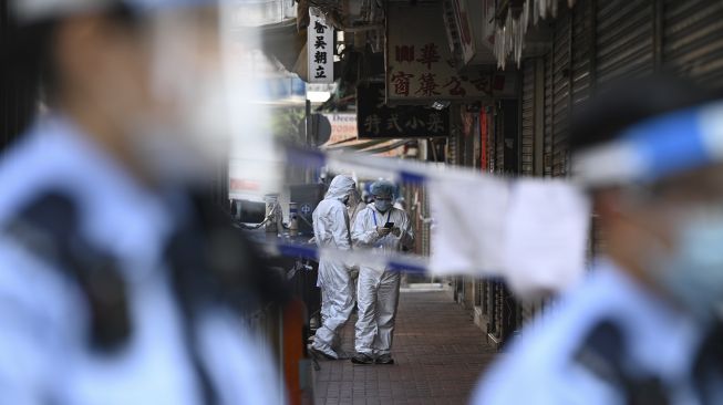 Petugas kesehatan bersiap untuk melakukan pengujian di daerah Yordania, Hong Kong, Sabtu (23/1/2021). [Peter PARKS / AFP]