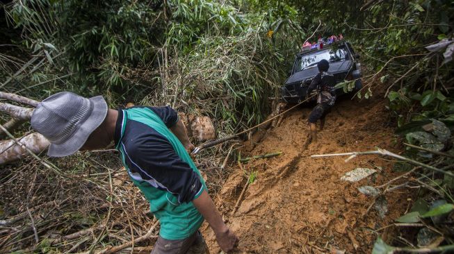 Relawan menggunakan mobil 4x4 mengantarkan logistik bantuan korban bencana tanah longsor menuju ke Desa Arangani di Kecamatan Hantakan, Kabupaten Hulu Sungai Tengah, Kalimantan Selatan, Jumat (22/1/2021). [ANTARA FOTO/Bayu Pratama S]