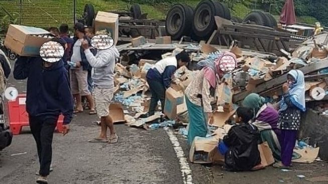 Oknum warga berbondong-bondong menjarah isi muatan truk yang terguling di Tawangmangu (Instagram)