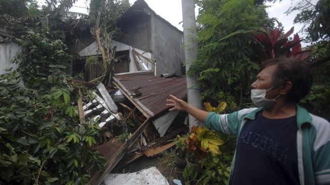 Warga memperlihatkan kondisi rumahnya yang terdampak longsor di Manado, Sulawesi Utara, Sabtu (23/1/12021). [ANTARA FOTO/Adwit B Pramono]