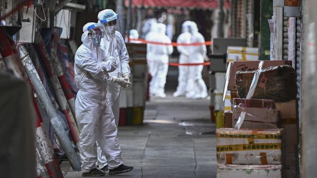 Petugas kesehatan bersiap untuk melakukan pengujian di daerah Yordania, Hong Kong, Sabtu (23/1/2021). [Peter PARKS / AFP]