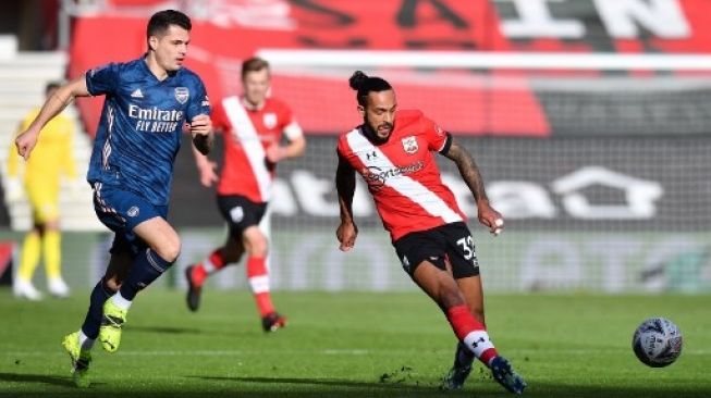 Pemain Southampton Theo Walcott melepaskan umpan saat menghadapi Arsenal di putaran keempat Piala FA di Saint Mary's Stadium, Sabtu (23/1/2021). [AFP]