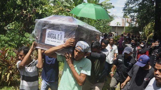 Keluarga dan kerabat mengangkat peti jenazah Angga Fernanda Afriyon untuk dimakamkan di Sungai Sapiah, Padang, Sumatera Barat, Sabtu (23/1/2021). [ANTARA/Iggoy el Fitra]