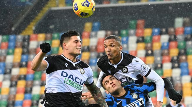 Bek Udinese Kevin Bonifazi, penyerang Inter Milan Lautaro Martinez (Bawah) dan gelandang Udinese Rodrigo De Paul melakukan sundulan selama pertandingan sepak bola seri A Italia Udinese melawan Inter Milan di Dacia Arena, Minggu (24/1/2021) dini hari WIB. Vincenzo PINTO / AFP