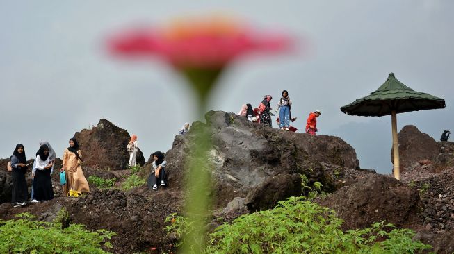 Sejumlah wisatawan mengunjungi kawasan Geowisata blok Seureuh Jawa, Tarogong Kaler, Kabupaten Garut, Jawa Barat, Minggu (24/1/2021). [ANTARA FOTO/Candra Yanuarsyah]
