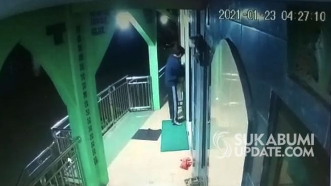 Tangkapan layar seorang pemuda terekam kamera CCTV tengah membobol kotak amal Masjid Al Barokah Cikondang, Sukabumi, [Ist]