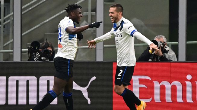 Penyerang Atalanta Duvan Zapata (kiri) merayakan golnya dengan bek Atalanta Rafael Toloi setelah mencetak gol ketiga dalam pertandingan sepak bola Serie A Italia AC Milan melawan Atalanta di Stadion San Siro, Minggu (24/1/2021) dini hari WIB
MIGUEL MEDINA / AFP