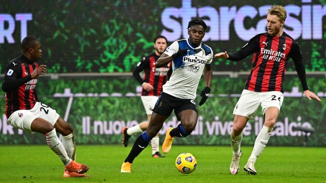 Penyerang Atalanta Duvan Zapata (tengah) berduel dengan bek AC Milan Simon Kjaer (kanan) dalam pertandingan sepak bola Serie A Italia AC Milan melawan Atalanta di Stadion San Siro, Minggu (24/1/2021) dini hari WIB. [MIGUEL MEDINA / AFP]

