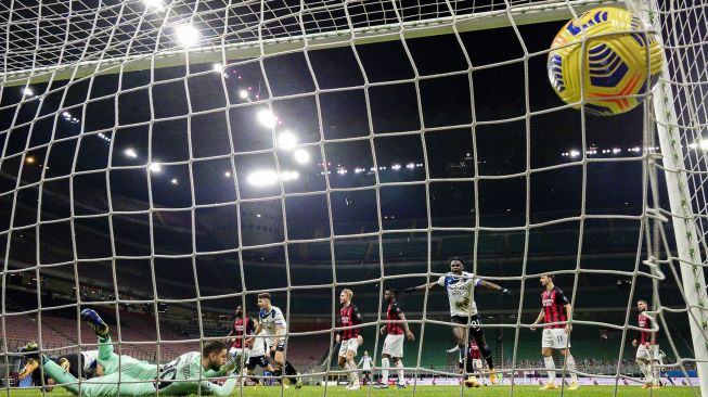 Penyerang Atalanta Duvan Zapata (kanan) membobol gawang  kiper AC Milan Gianluigi Donnarumma dalam pertandingan sepak bola Serie A Italia AC Milan melawan Atalanta di Stadion San Siro, Minggu (24/1/2021) dini hari WIB. [MIGUEL MEDINA / AFP]