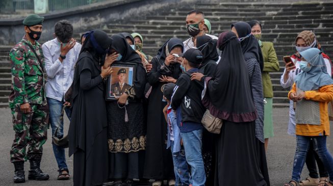 Keluarga dari almarhum Praka (Anumerta) Roy Vebrianto, Anggota Yonif Raider 400/BR meluapkan kesedihan sebelum pemakaman jenazah di Taman Makam Pahlawan, Cikutra, Bandung, Jawa Barat, Minggu (24/1/2021). [ANTARA FOTO/Raisan Al Farisi]
